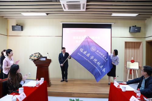 学校校友办副主任薛少聪向会长授旗